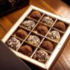 A gourmet selection of chocolate truffles in an elegant box, perfect for indulgence.